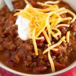 Bowl of crockpot chili with cheese and sour cream.