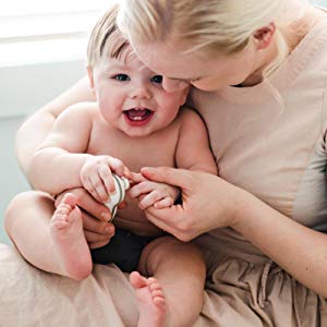 Mother cuts baby\'s fingernails.