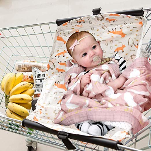 Baby sits in shopping cart sling.