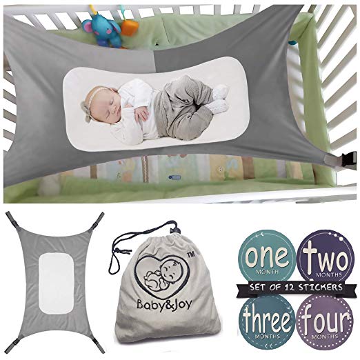 Baby sleeps in gray baby crib hammock.