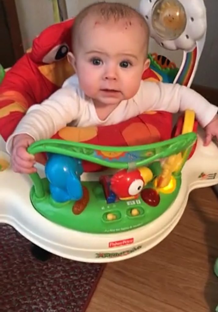 Baby plays in Jumperoo baby entertainment center.