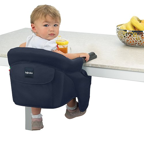 Portable high chair with baby attached to table.