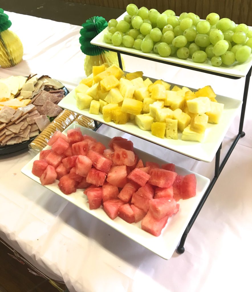 Tiered fruit stand with grapes, pineapples and watermelon.