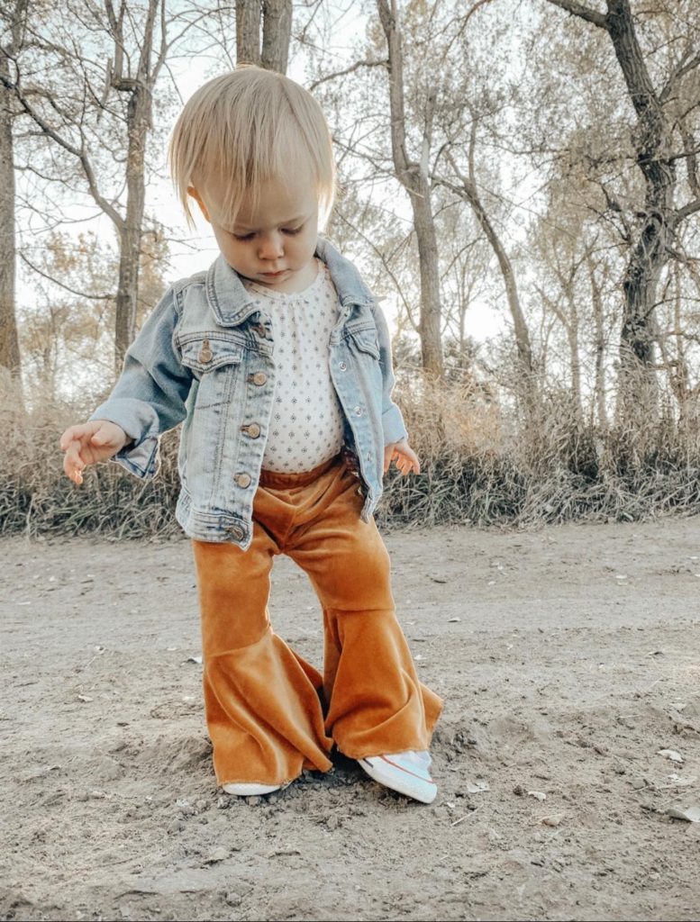 Toddler girl in denim jacket and velvety pants.