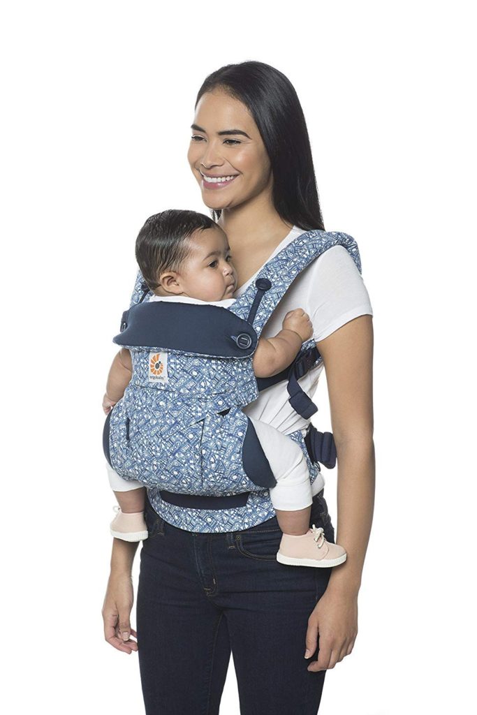 Woman models baby carrier with small child.